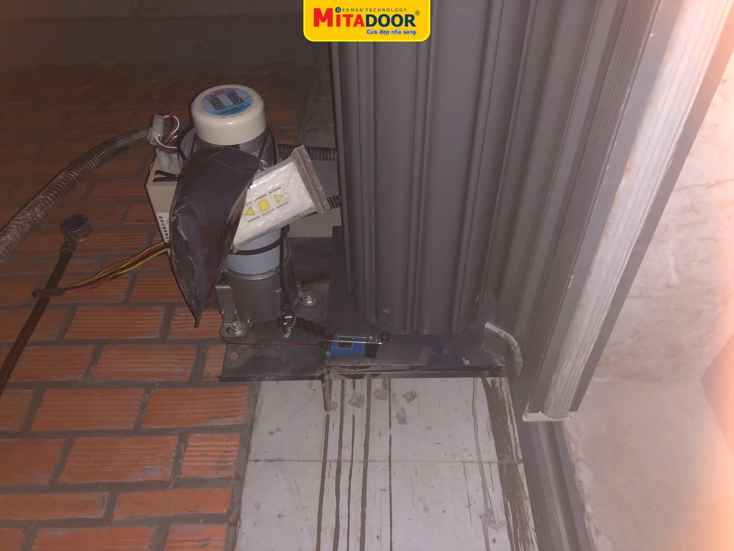 Hệ thống chống xổ l&ocirc; cuốn của Mitadoor gắn tr&ecirc;n bản lắc motor, gi&uacute;p cửa cuốn th&eacute;p kh&ocirc;ng bị xổ l&aacute;