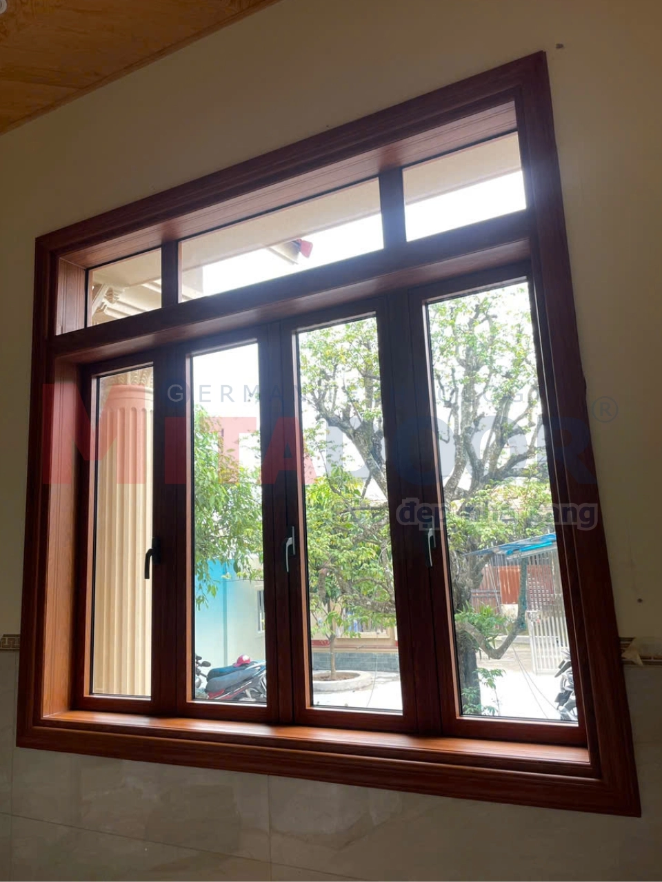 Cửa sổ nhôm kính màu vân gỗ kết hợp cùng phụ kiện đồng bộ, mang lại nét đẹp sang trọng và ấm cúng cho không gian