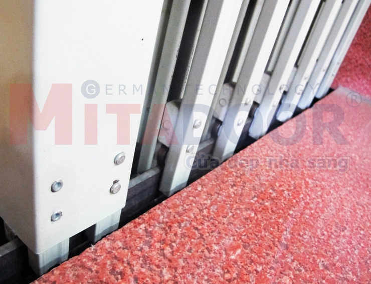Chi tiết ray dưới cửa k&eacute;o th&eacute;p Mitadoor sơn tĩnh điện, b&aacute;nh xe trượt c&oacute; bạc đạn gi&uacute;p cửa vận h&agrave;nh &ecirc;m, nhẹ
