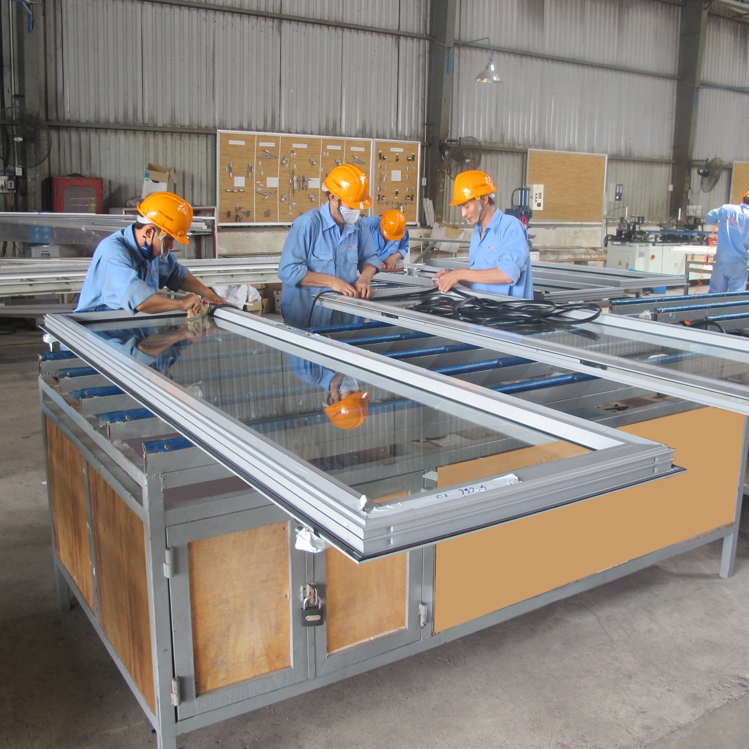 Thợ kỹ thuật đang ho&agrave;n thiện cửa nh&ocirc;m k&iacute;nh tại xưởng 