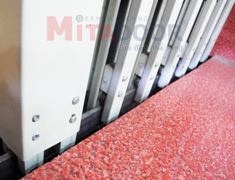 Chi tiết ray dưới cửa kéo thép Mitadoor sơn tĩnh điện, bánh xe trượt có bạc đạn giúp cửa vận hành êm, nhẹ Chi tiết ray dưới cửa kéo thép Mitadoor sơn tĩnh điện, bánh xe trượt có bạc đạn giúp cửa vận hành êm, nhẹ