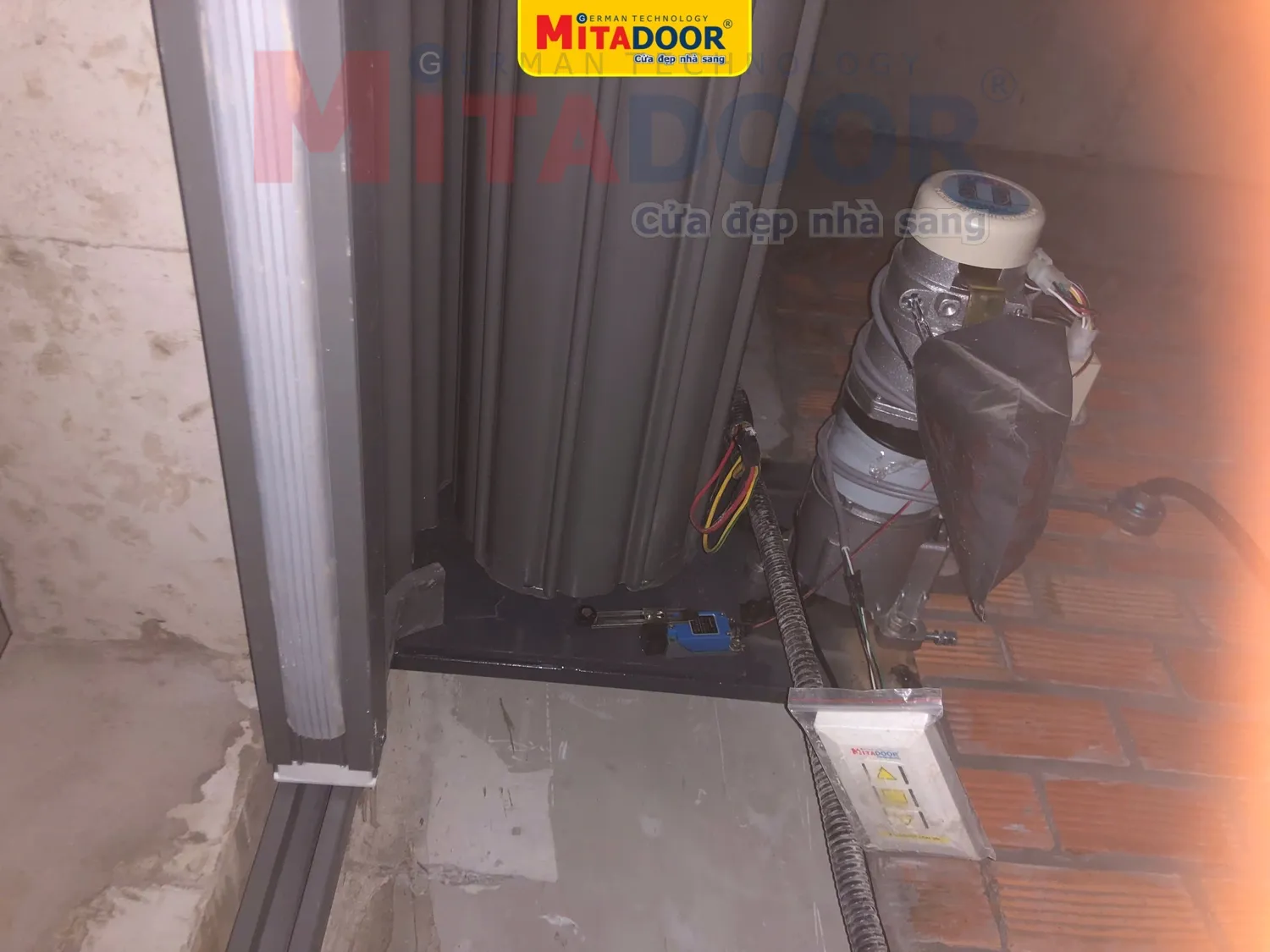 Hệ thống chống xổ l&ocirc; cuốn của Mitadoor gắn tr&ecirc;n bản lắc motor, gi&uacute;p cửa cuốn th&eacute;p kh&ocirc;ng bị xổ l&aacute;