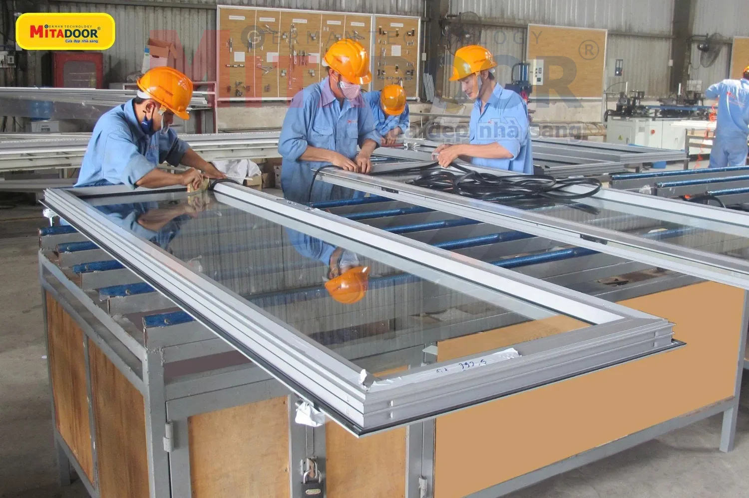 Thợ kỹ thuật đang ho&agrave;n thiện cửa nh&ocirc;m k&iacute;nh tại nh&agrave; m&aacute;y Mitadoor