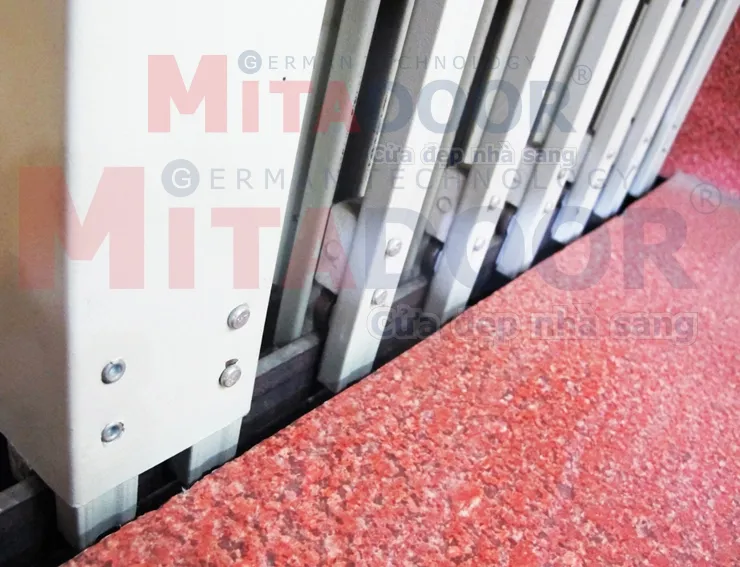 Chi tiết ray dưới cửa k&eacute;o th&eacute;p Mitadoor sơn tĩnh điện, b&aacute;nh xe trượt c&oacute; bạc đạn gi&uacute;p cửa vận h&agrave;nh &ecirc;m, nhẹ