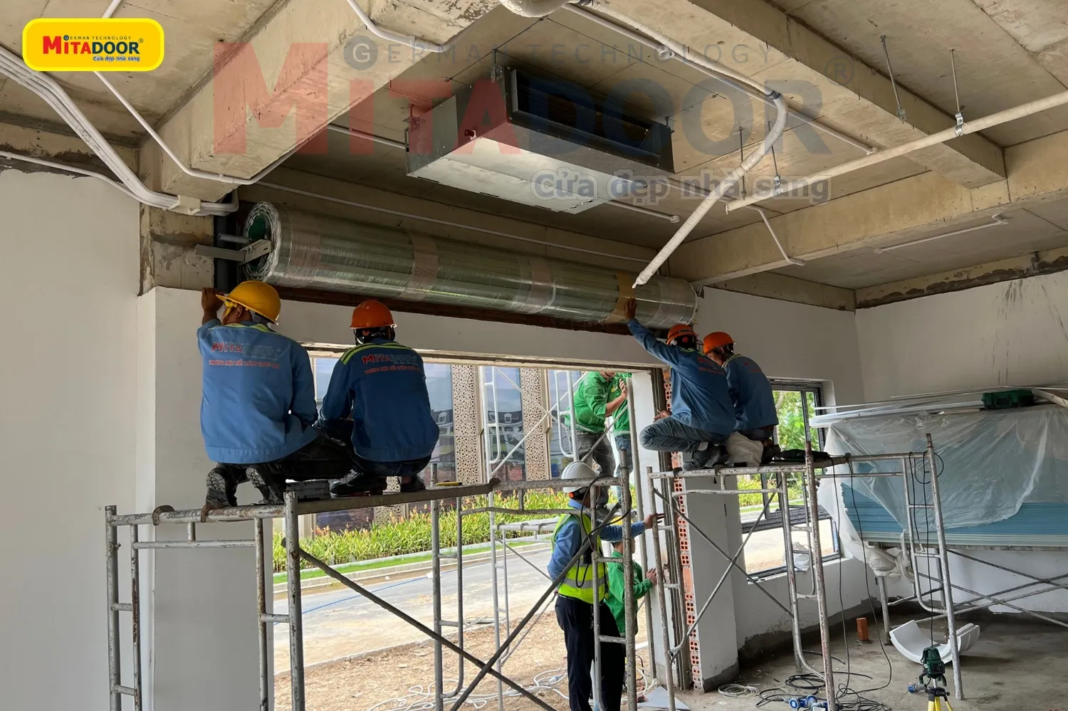 Bộ phận kỹ thuật đang lắp đặt hệ thống cửa cuốn tại c&ocirc;ng tr&igrave;nh