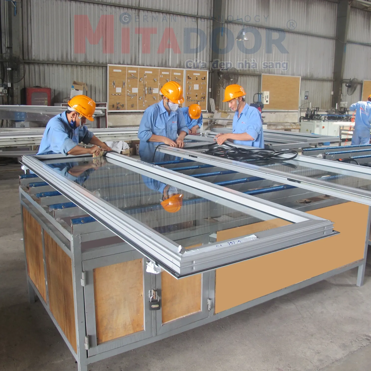 Thợ kỹ thuật đang ho&agrave;n thiện cửa nh&ocirc;m k&iacute;nh tại xưởng 